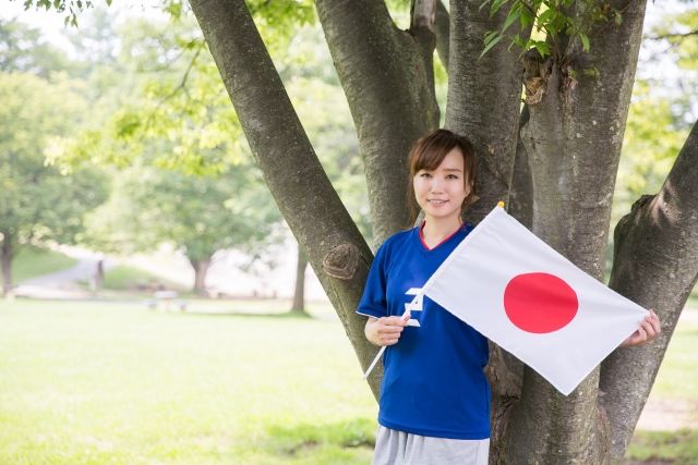 公園で日の丸の旗を持っている女性